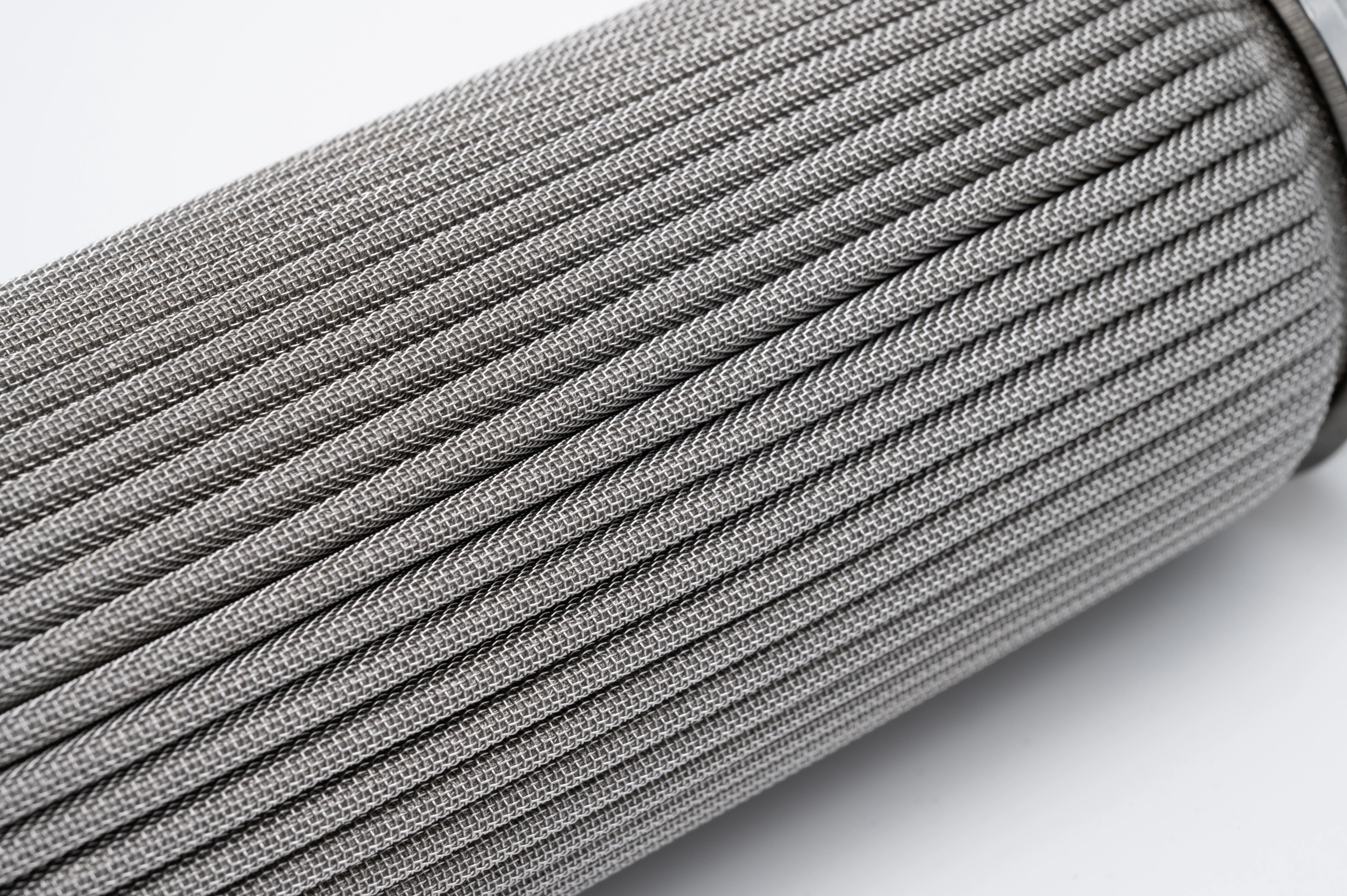 Close-up of pleated stainless steel mesh filter cartridge used for reusable industrial liquid filtration