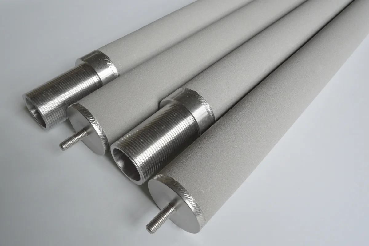 Close-up of stainless steel sintered powder filter cartridges showing porous filtration surface and threaded connections